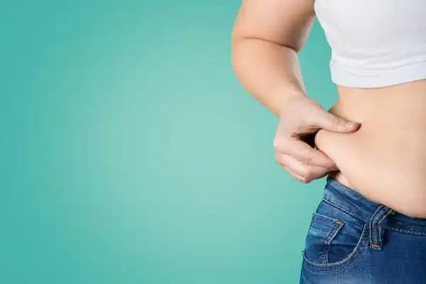 Image of woman pinching her love handles to show weight gain Harpenden